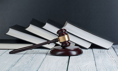 Gavel sitting in front a five books